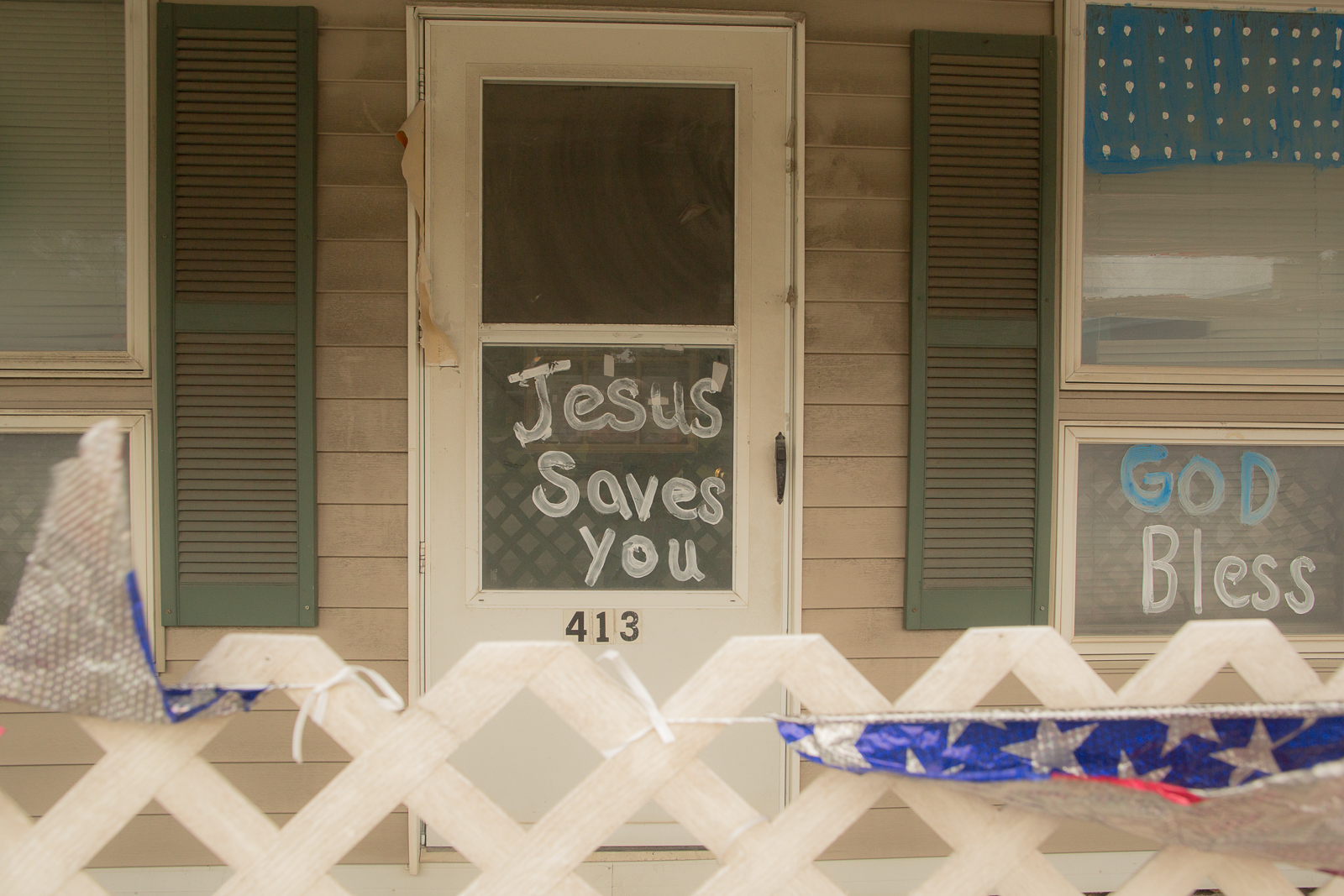 'Jesus saves you' sign on old door with a screen