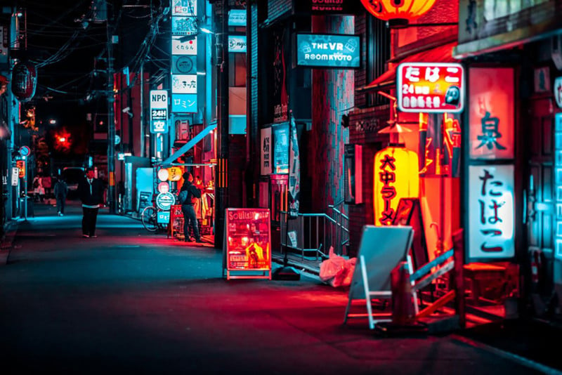 Street shot of Kyoto at night: side view of neon lit shopping area, blurred and yellow lighting