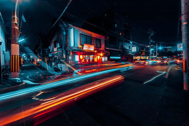 Street shot of Kyoto at night: long exposure teal and red light with small house and telephone wires 