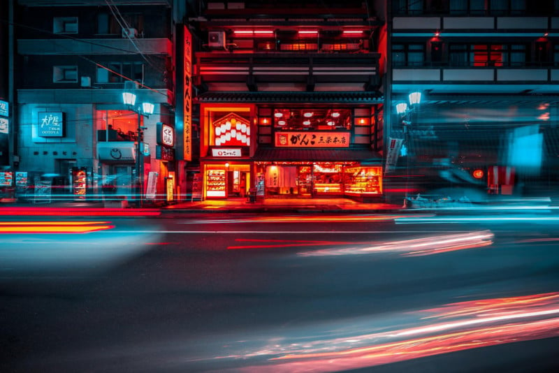 Street shot of Kyoto at night: long exposure teal and red light with dark black sky and forward facing view of building