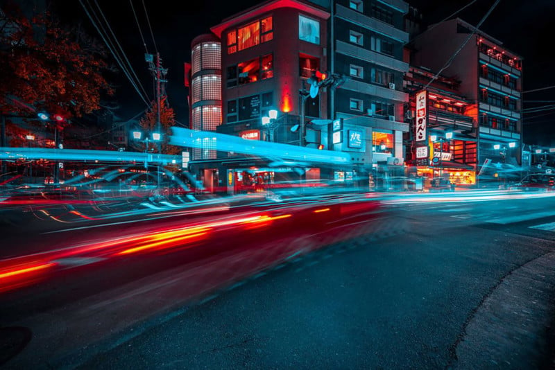 Street shot of Kyoto at night long exposure teal and red light with apartment complex in background