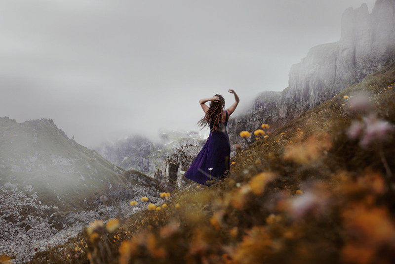 Woman on steep hill side of meadow in Switzerland