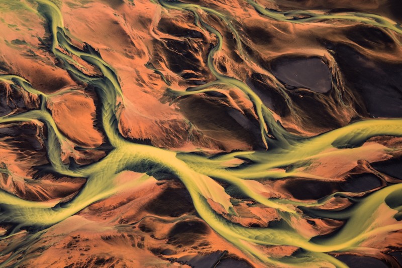 Abstract terrain that is bright green and orange resembling river ways