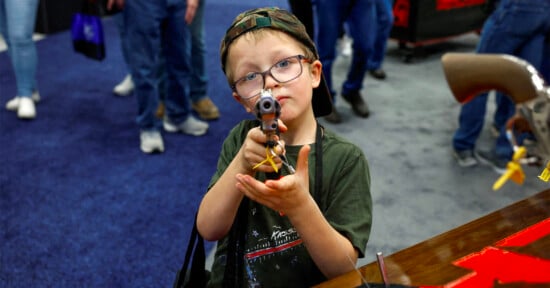 Young boy points gun at the camera