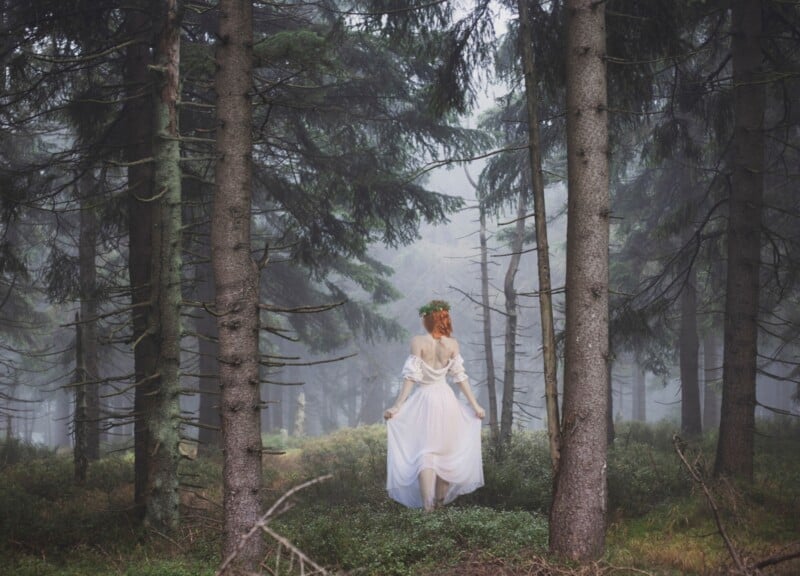 Jeune femme aux cheveux rouges marchant dans une forêt brumeuse, vêtue d'une robe transparente 