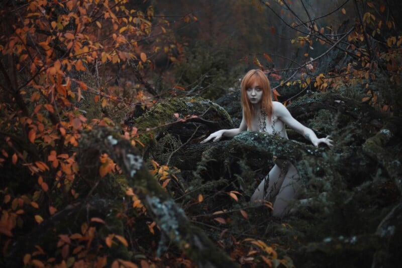 jeune femme pâle aux cheveux rouges dans les arbres ressemblant à une fée 