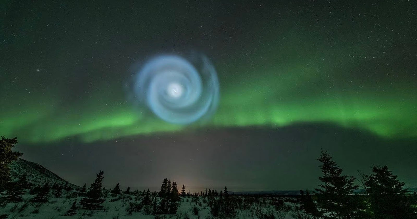 알래스카 밤하늘의 오로라 가운데 거대한 나선이 나타납니다.