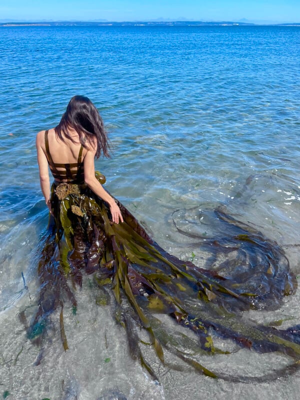 A woman wearing a skirt made of seaweed. 