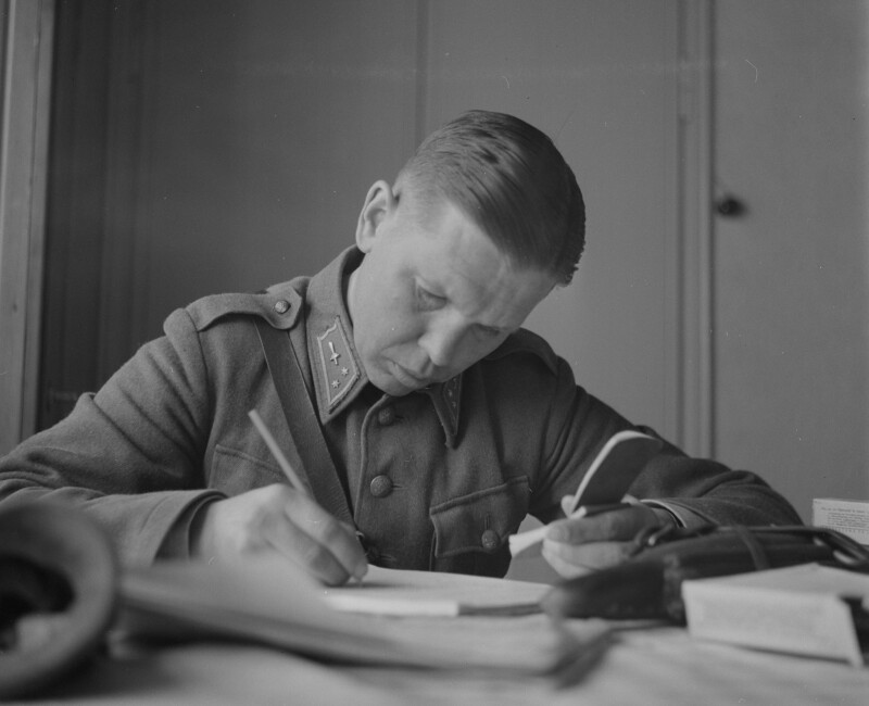 Photograph of the Finnish photographer Osvald Hedenström (1913–1998) writing captions in Savukoski.