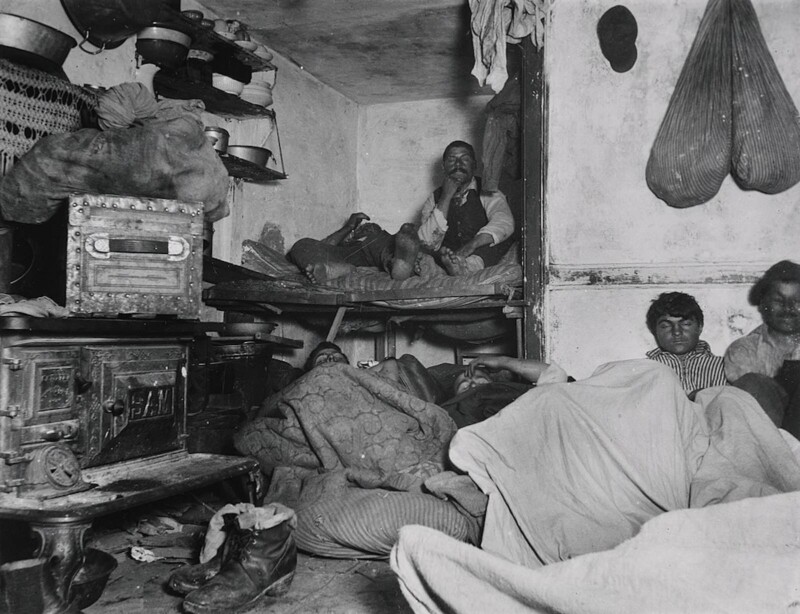 Beaucoup d'hommes dormant sur des lits superposés et des matelas dans une petite pièce