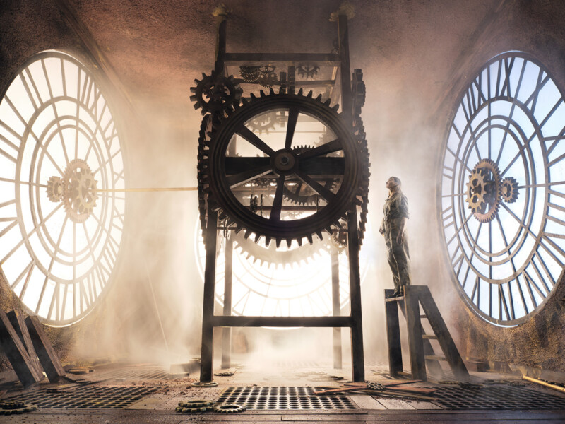 Sepia toned imagery of showing the inside of a clock tower and a man stand-in int light 