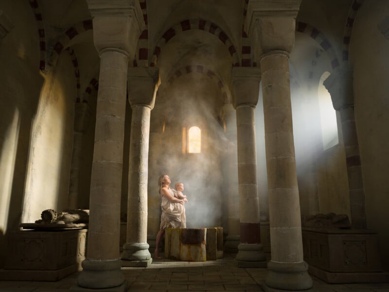 A parent holding A child in a misty ancient temple, with light peering through the window 