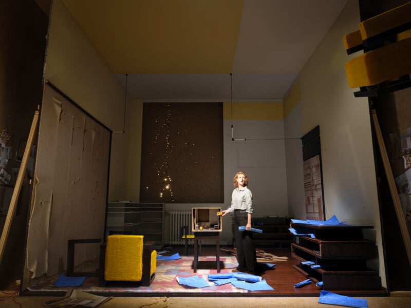 a semi contemporary room with yellow and white ceiling and a woman wearing a white shirt looking upwards 