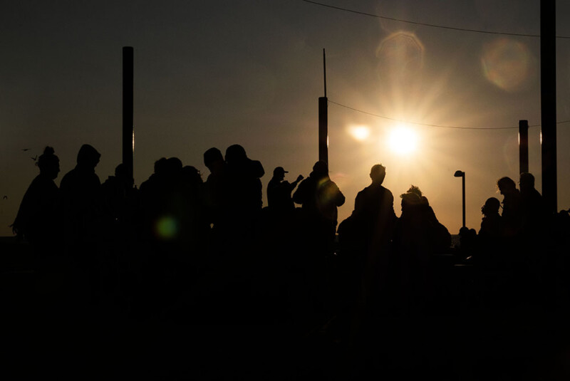 A crowd of people playing music at sunset