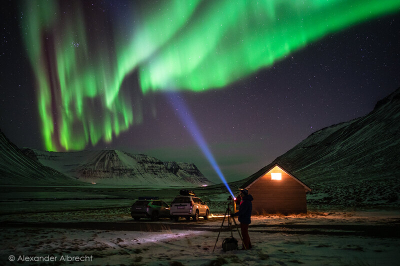 Photographer beneath the northern lights in Iceland