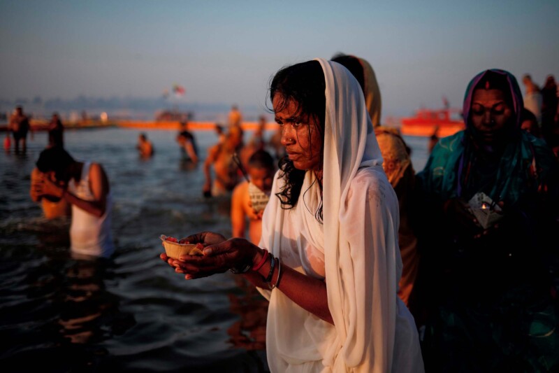 Devotees pray after taking a holy dip at Sangam