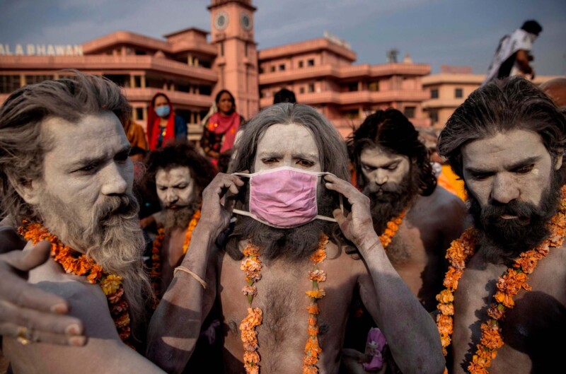 A Hindu holy man wears a mask before the procession for taking a dip in the Ganges river 