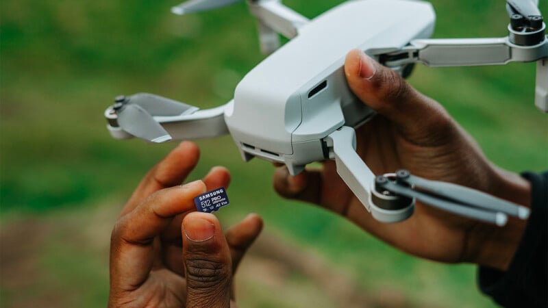 One of Samsung's Pro Ultimate microSD cards is seen in hand alongside a drone.