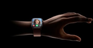 An Apple Watch is seen on someone's wrist against a black background.