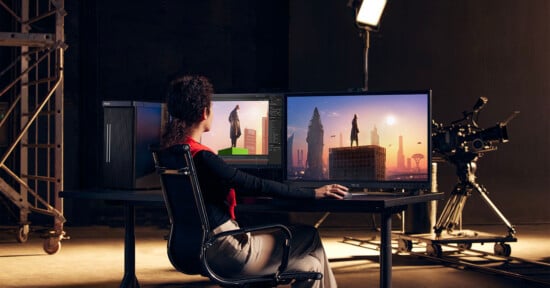 A woman sits a desk in a studio editing video on the Asus ProArt Station.