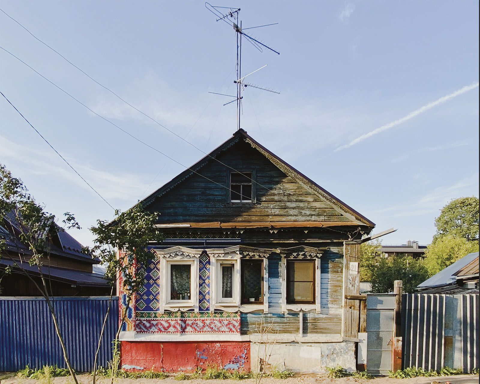 A dacha home with differing colors separated down the middle.