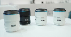 Sirui Sniper f/1.2 lenses for APS-C mirrorless cameras, shown in white and black. Four prime lenses displayed on a table.