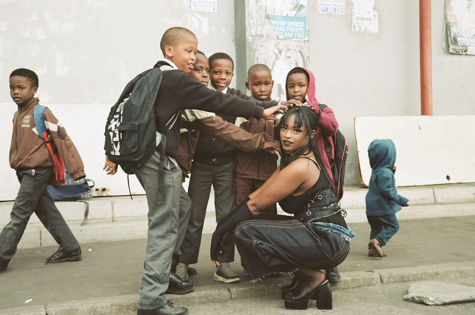 A woman poses and children smile in a group.