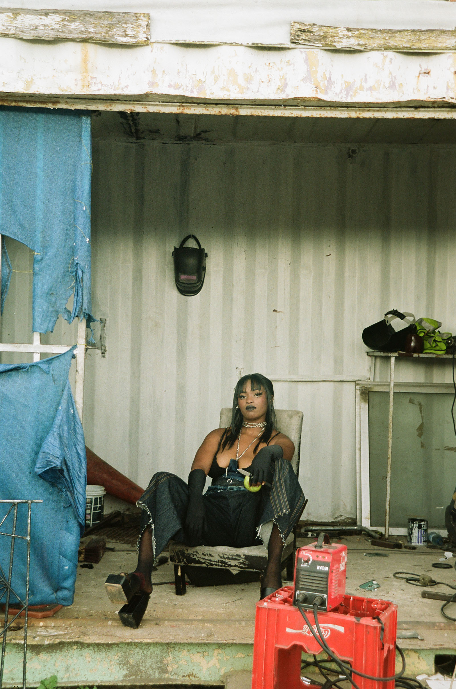 A woman sits, posing at the camera.