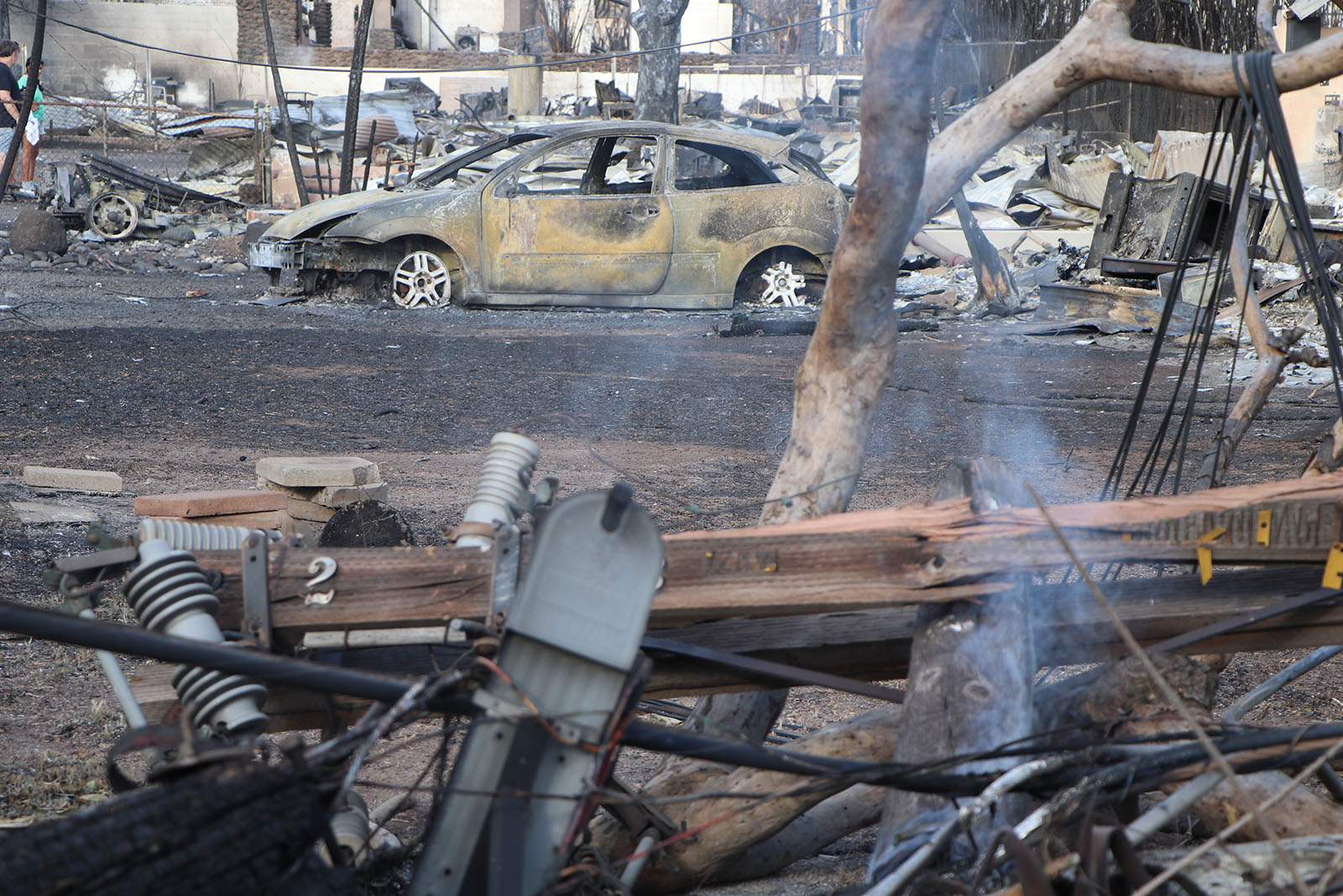 A burnt car surrounded by gnarled metal after the wildfires.