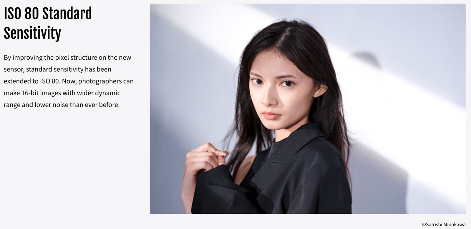 Portrait of a woman wearing a black shirt against a gray background. Woman is looking at the camera. 