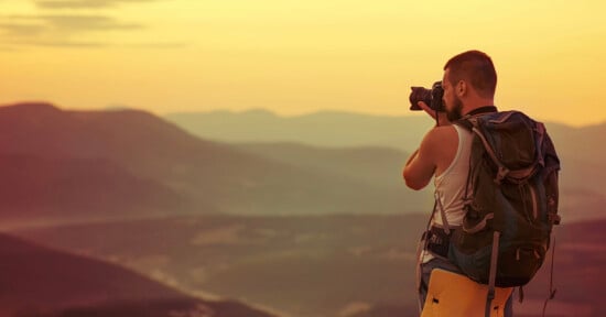 man takes a photo among mountains