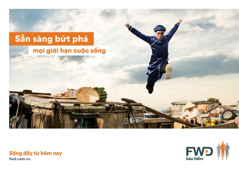 Tear sheet of runner in blue traditional Vietnamese garment. leaping from first story roof, by Vietnam-based Lifestyle Photographer Tim Gerard Barker