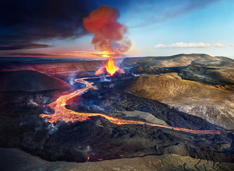 A landscape image of a volcano moves from day to night in the image from left to right.