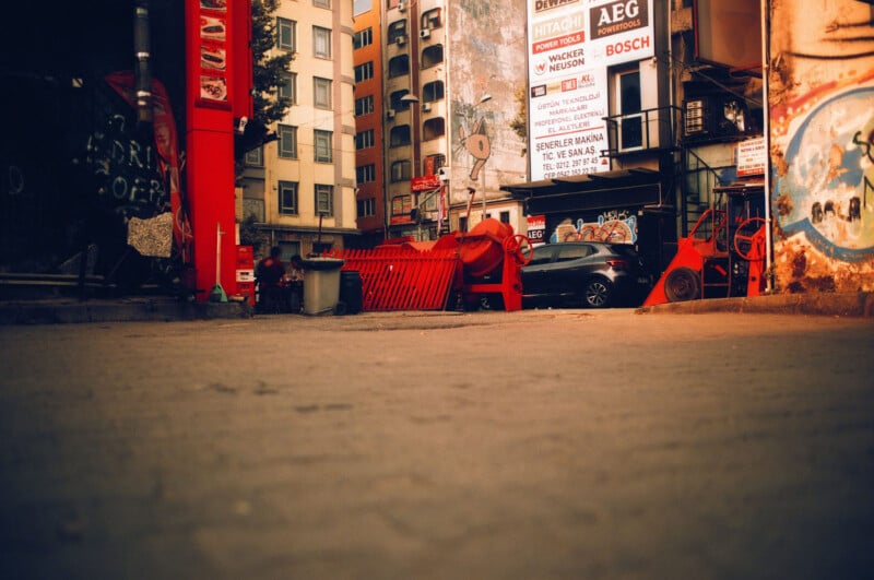 A street scene with graffiti and red machinery. 