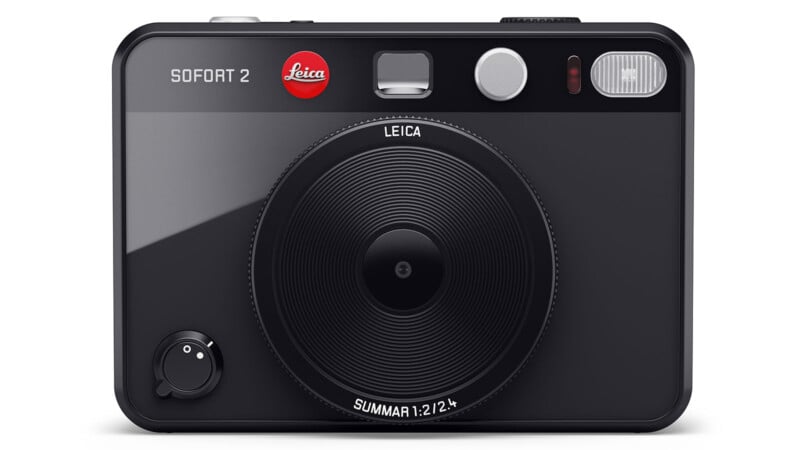 A black Leica Sofort 2 camera model against a white backdrop.