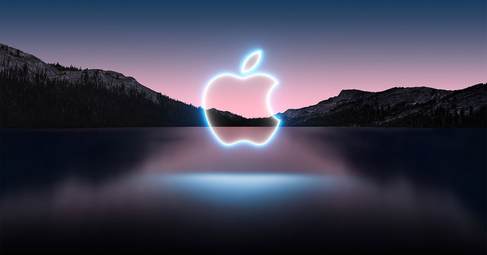 Glowing blue Apple logo against a sunset backdrop of a lake and mountains.