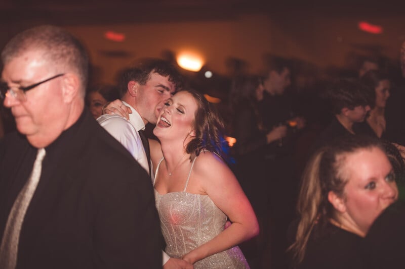 A bride and groom sharing a moment on the dance floor among guests.