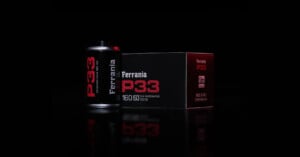 A roll of Ferrania P33 sits next to its box against a black background.