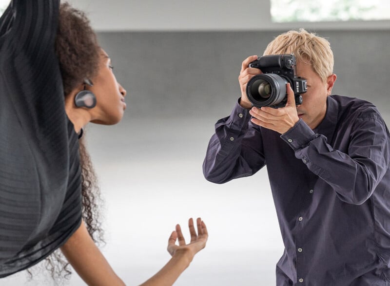 Photographer using a Nikon Z9 digital mirrorless camera to photograph a woman. 