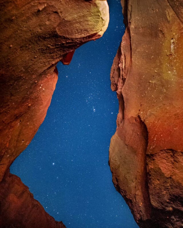 Red rocks frame a night sky filled with stars.