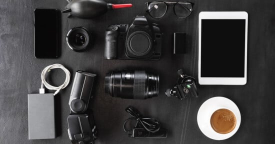 A mix of photography equipment laid out on a black table.