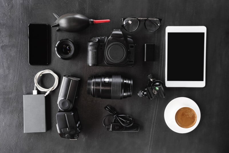 A mix of photography equipment laid out on a black table.