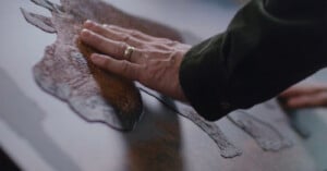 A person touches of a photo of a rhino featuring elevated texture.