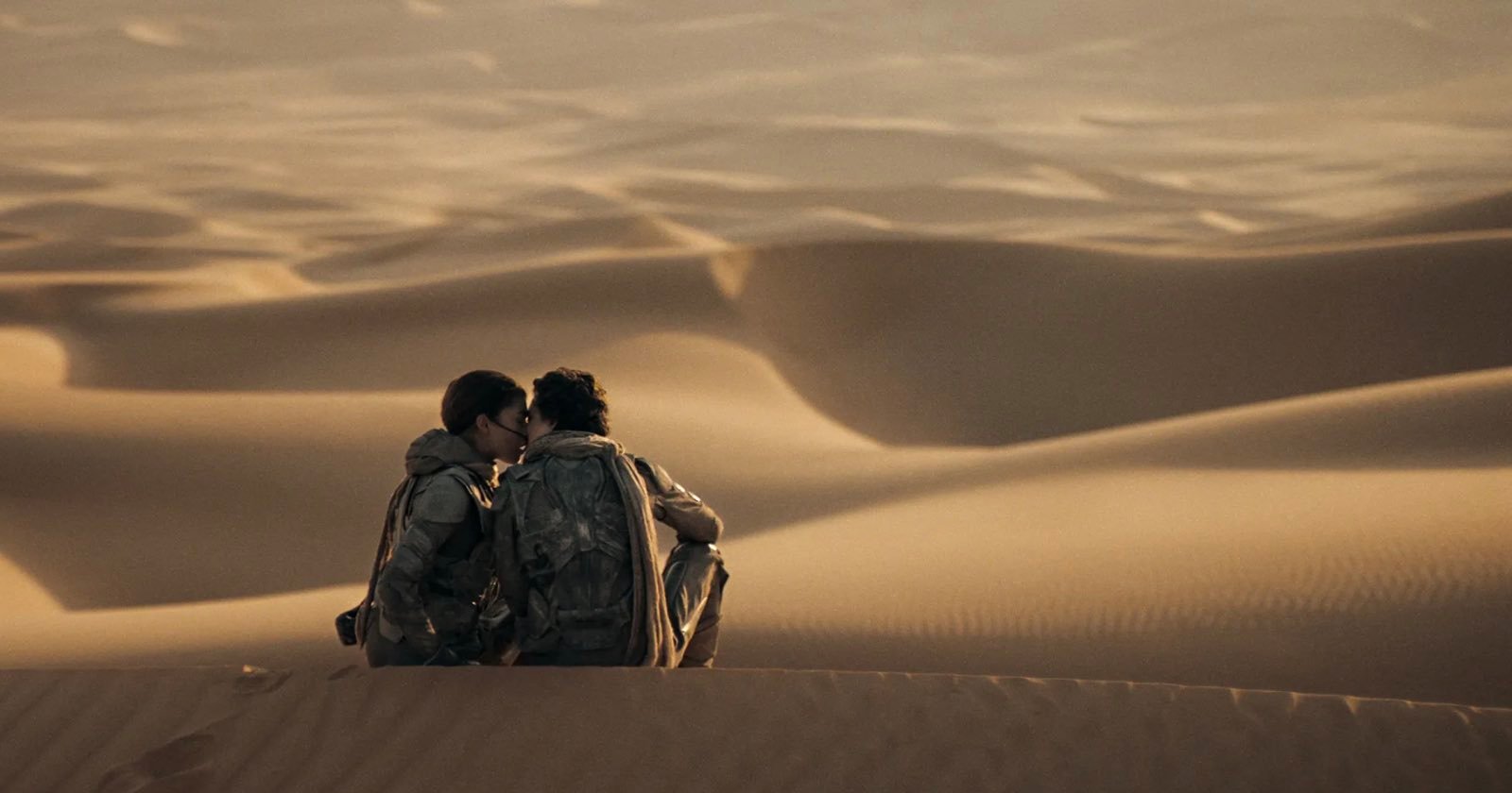 Chalamet and Zendaya kiss in a vast desert in "Dune: Part Two"