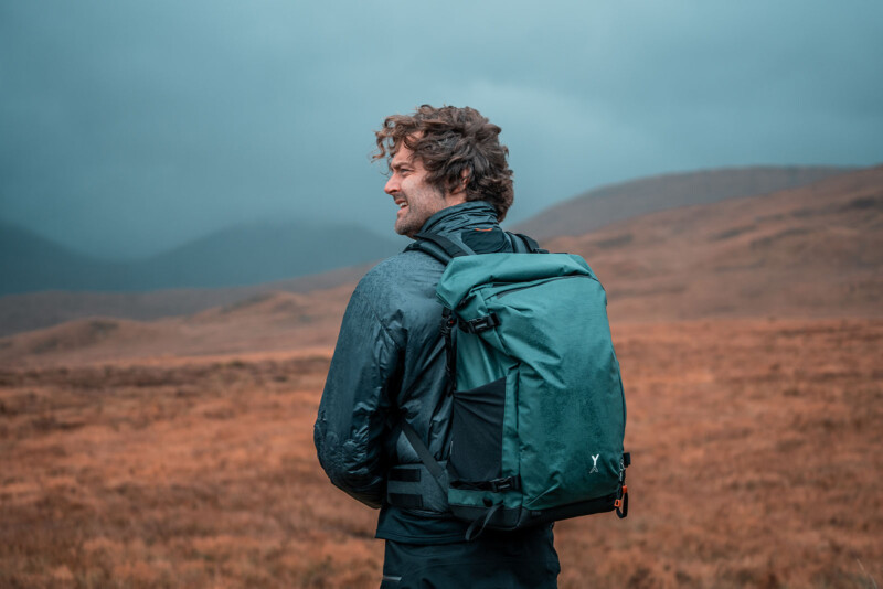 A person wears the Fjord 50-C backpack in pine.