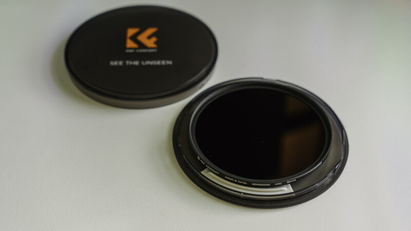 The K&F CONCEPT filter sits in its case on a white desk.