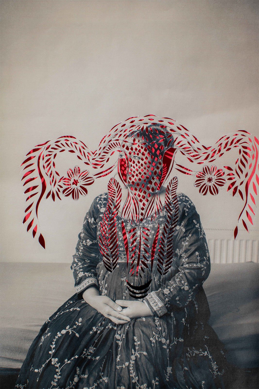 A surreal black and white photograph of a person sitting, wearing a detailed patterned headdress with octopus-like tendrils and intricate designs, giving an artistic and mysterious vibe.