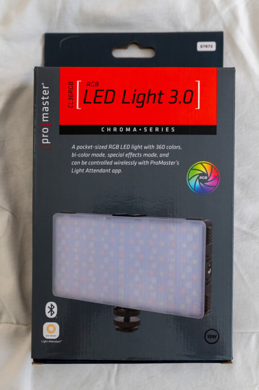 A packaged "promaster led light 3.0" on a bed, featuring a pocket-sized rgb led light with 360 colors, bi-color mode, special effects, wireless control, and a light attendant app.