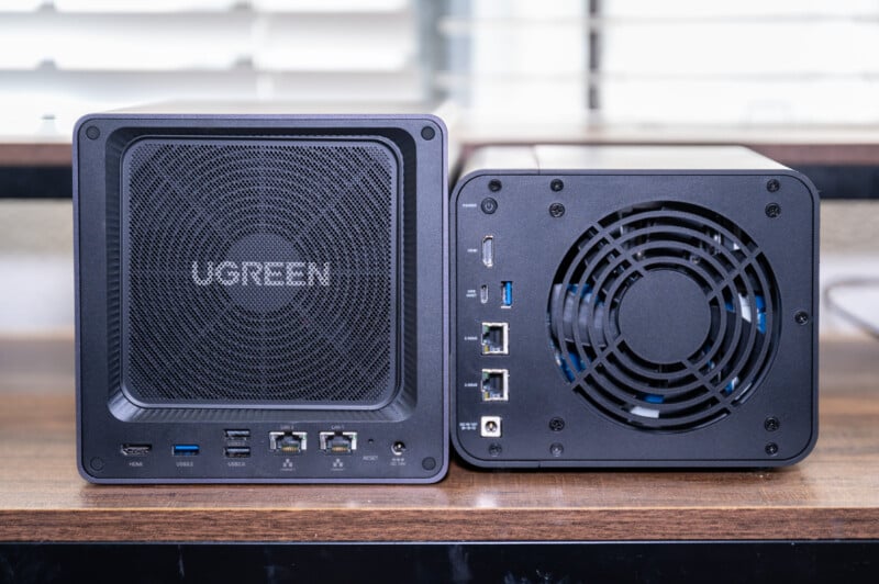 Two ugreen external hard drive enclosures on a table, one showing the front with ports and branding, the other displaying its rear with a cooling fan and additional ports.