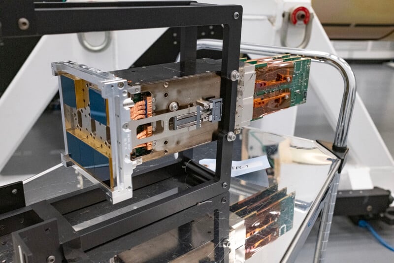 The intricate LSST sensor raft device featuring metallic structures with copper accents and intricate wiring, surrounded by technical equipment.